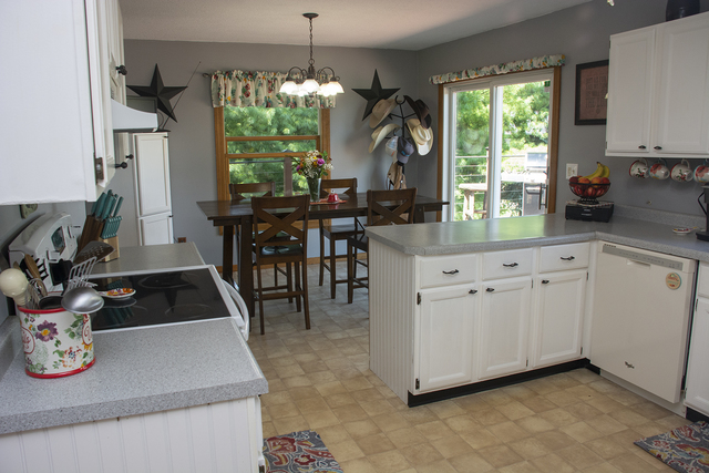 15755 Hillside Road Morrison, IL 61270 - Photo 8 of 26 a kitchen with white cabinets a dining table and chairs
