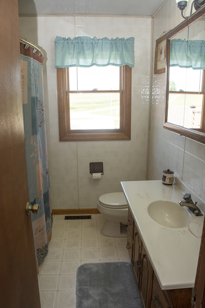 15755 Hillside Road Morrison, IL 61270 - Photo 10 of 26 a bathroom with a sink toilet and a window