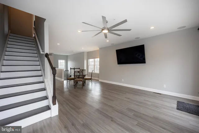 a view of a livingroom with wooden floor and furniture