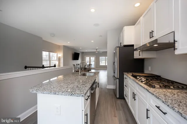 a kitchen with stainless steel appliances granite countertop a sink stove and refrigerator