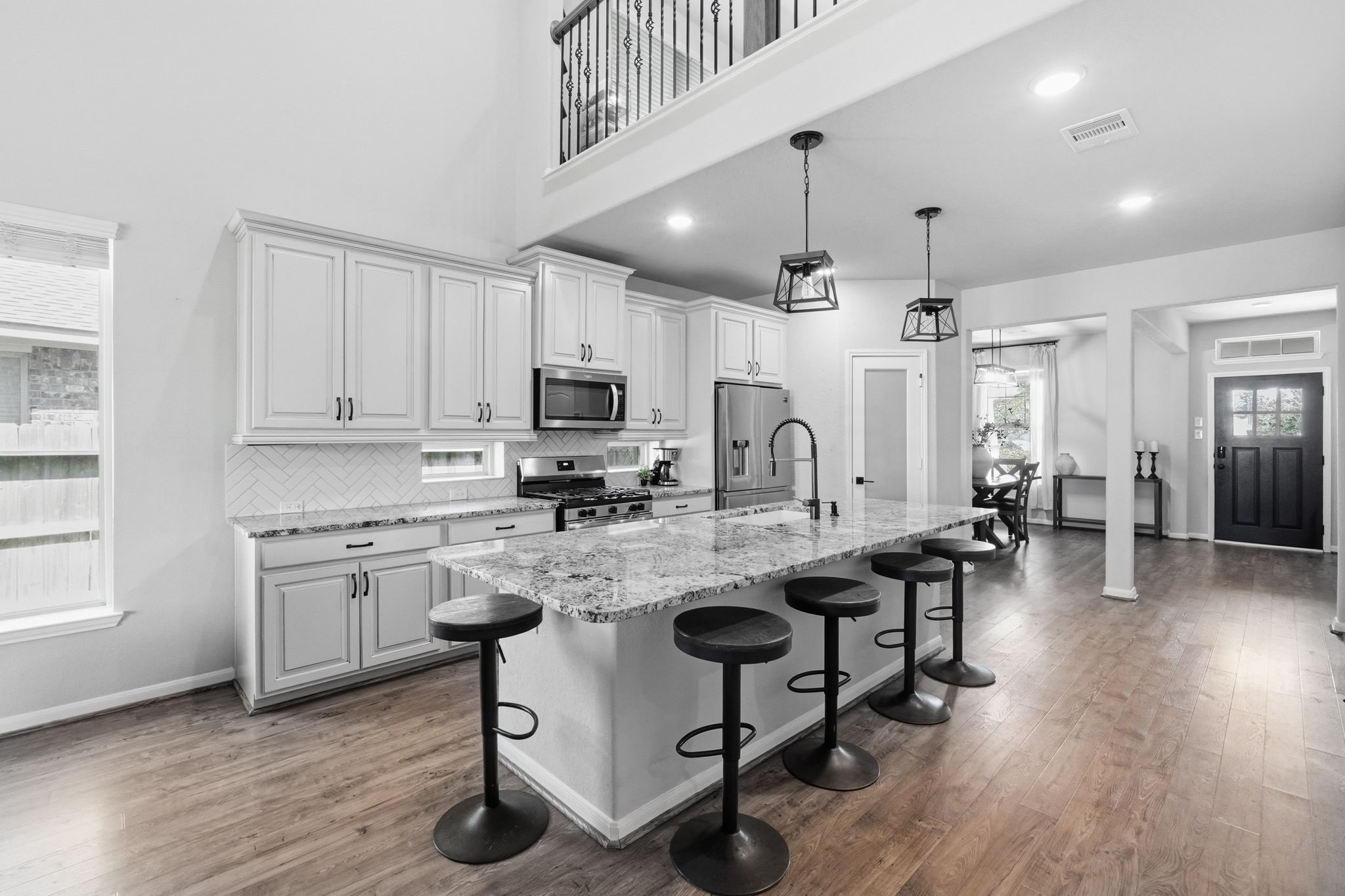 4334 Umber Shadow Drive Spring, TX 77386 - Photo 2 of 45 Kitchen showcases an oversized island with seating, cabinetry, stainless steel appliances, and an open-concept layout that flows seamlessly into the main living areas.
