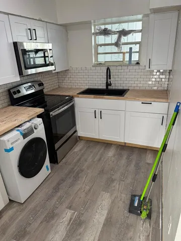 a kitchen with a sink a microwave a stove and refrigerator