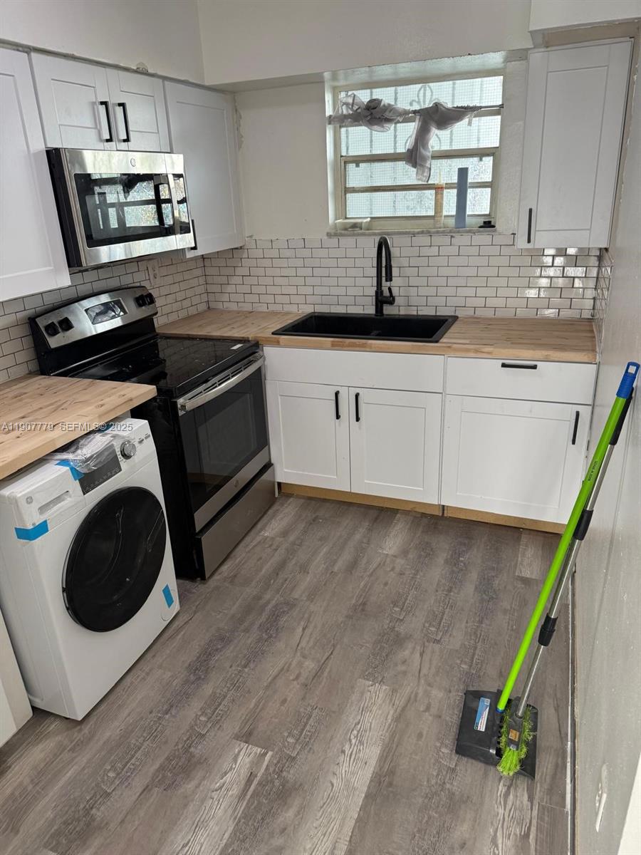 2498 Southwest 17th Avenue, Unit 4311 Miami, FL 33133 - Photo 3 of 15 a kitchen with a sink a microwave a stove and refrigerator