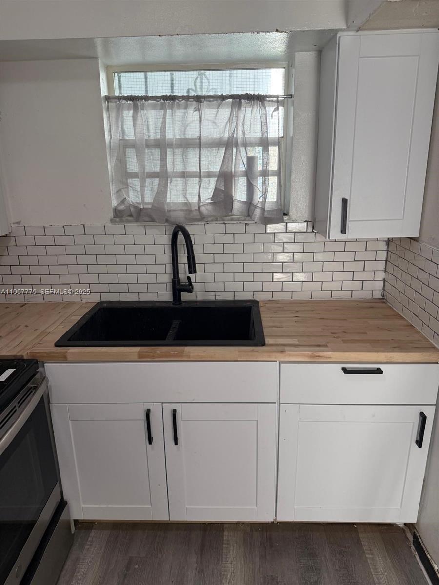 2498 Southwest 17th Avenue, Unit 4311 Miami, FL 33133 - Photo 5 of 15 a kitchen with white cabinets and sink