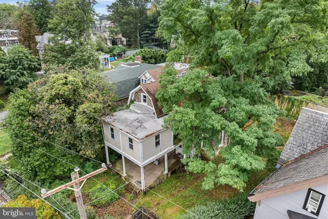 an aerial view of a house with a yard and large trees