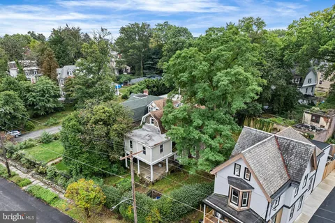 an aerial view of a house with outdoor space and trees all around