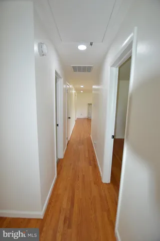 a view of a hallway with wooden floor