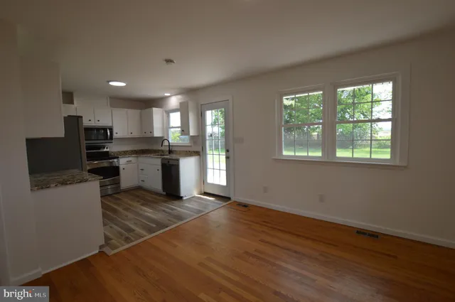 a kitchen with stainless steel appliances granite countertop a stove top oven a sink dishwasher and a refrigerator