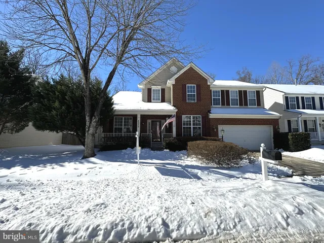 a front view of a house with a yard covered in snow