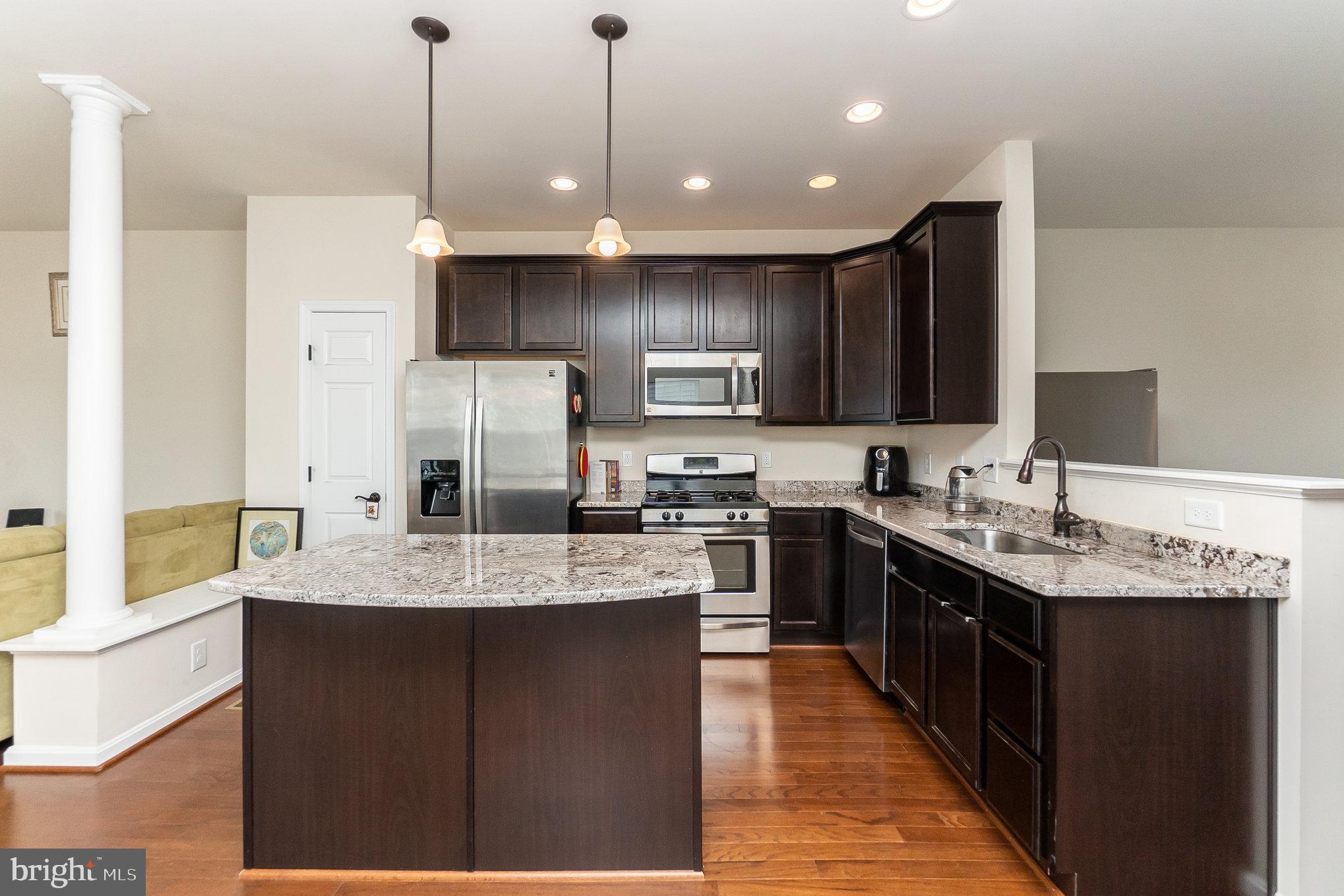 4711 Wensel Road Fredericksburg, VA 22408 - Photo 8 of 33 a kitchen with kitchen island granite countertop a sink a counter top space stainless steel appliances and cabinets