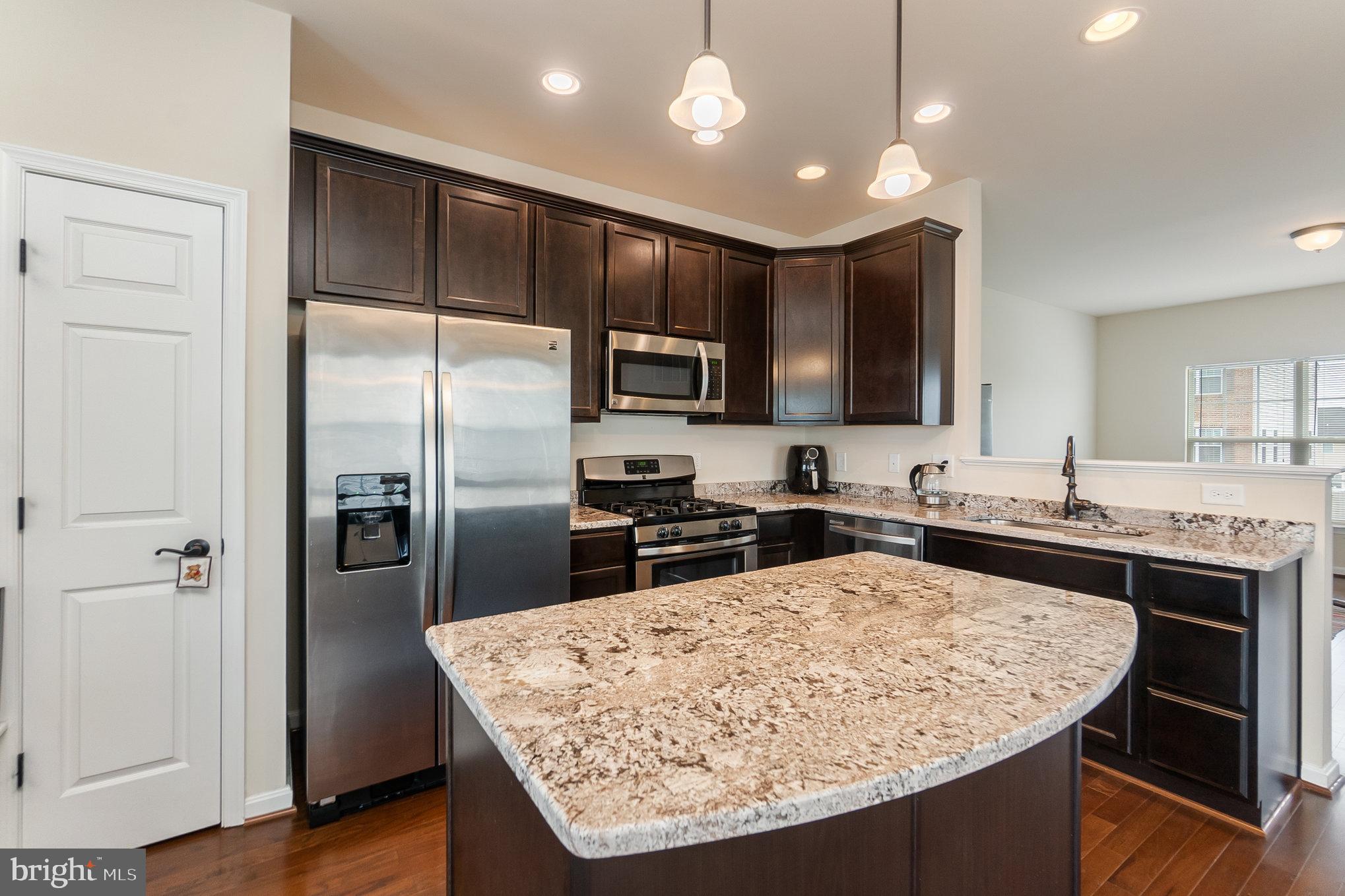 4711 Wensel Road Fredericksburg, VA 22408 - Photo 9 of 33 a kitchen with stainless steel appliances granite countertop a refrigerator a stove a sink a microwave and island
