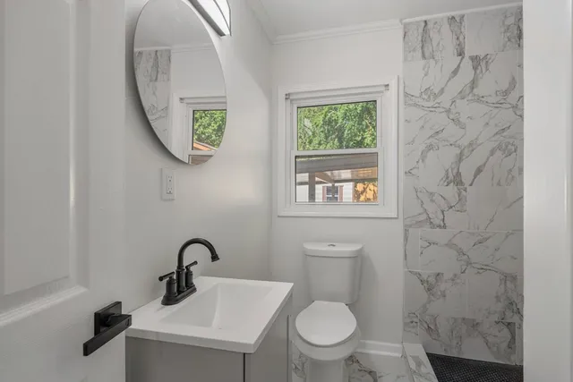 a bathroom with a toilet sink and mirror