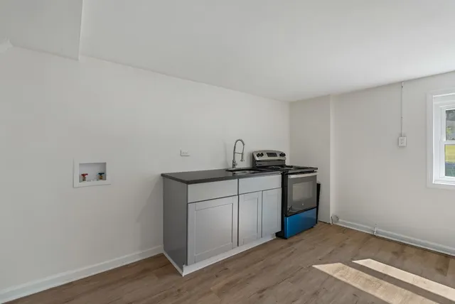 a kitchen with a sink cabinets and wooden floor