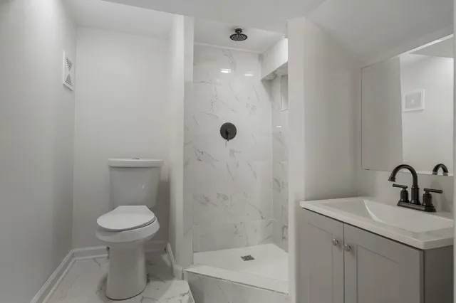 a bathroom with a sink a toilet and shower