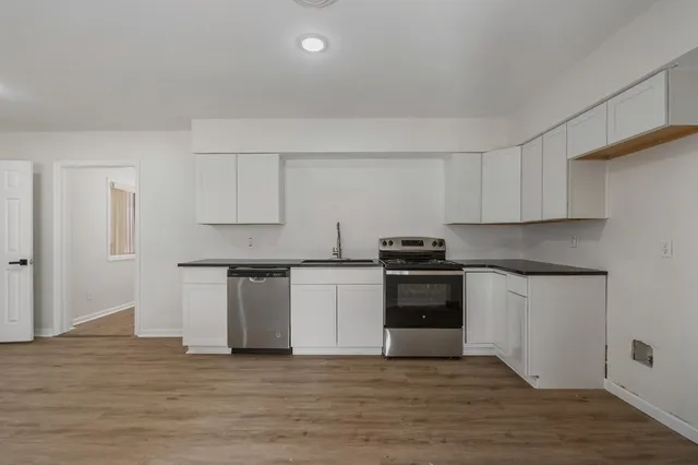 a kitchen with a white cabinets and stove top oven