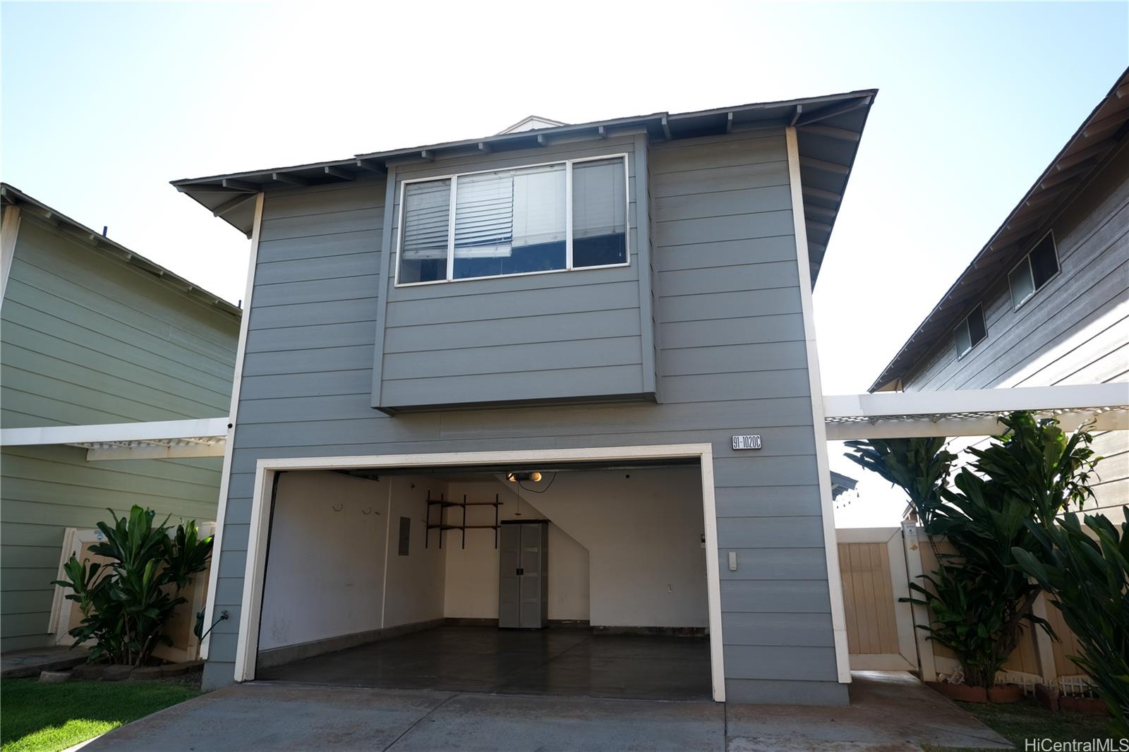 a front view of a house with plants