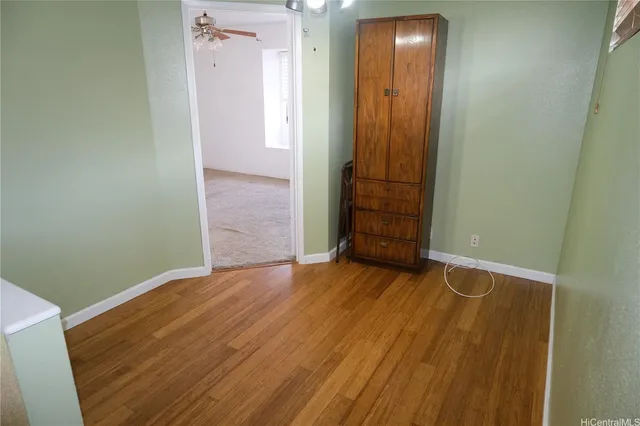 an empty room with wooden floor and entrance