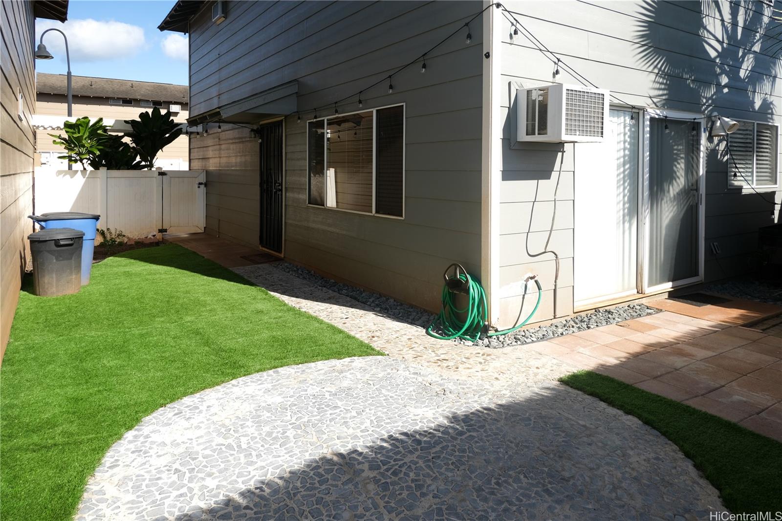 91-1020 Hoomaka Street, Unit 88 Ewa Beach, HI 96706 - Photo 19 of 22 a front view of a house with a yard and garage