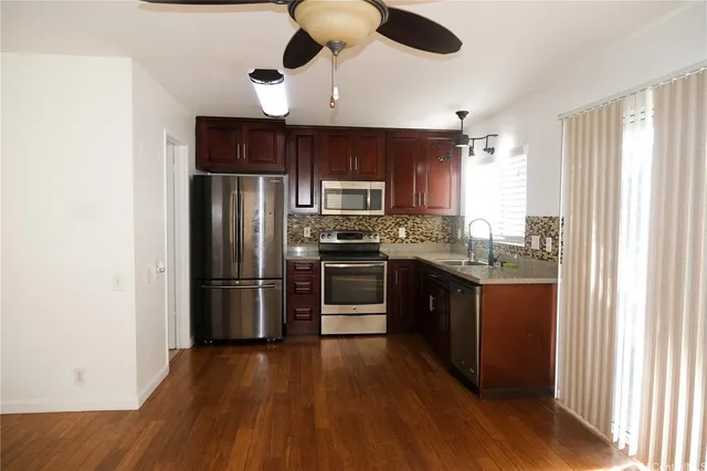 a kitchen with stainless steel appliances granite countertop a refrigerator a stove a sink and a microwave