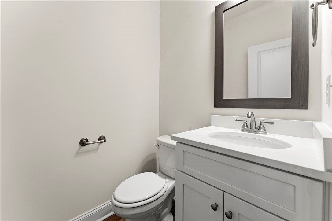 505 Fire Tower Road Williamston, SC 29697 - Photo 33 of 37 This functional bathroom features a sleek vanity, a toilet, and elegant wood flooring, creating a clean aesthetic.