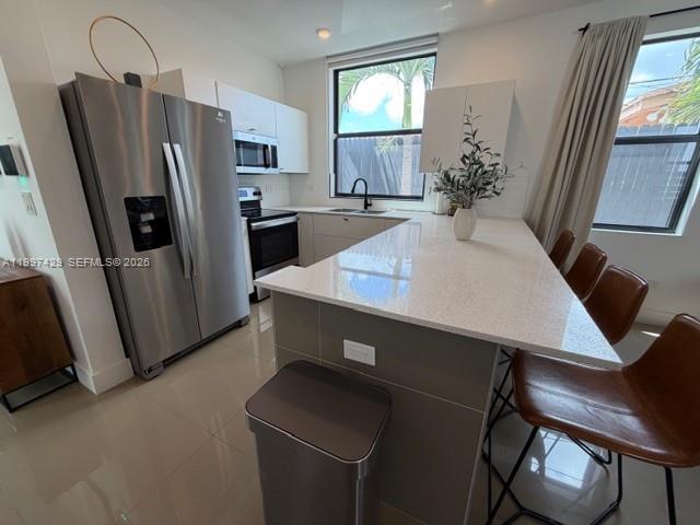 3645 Southwest 3rd Street Miami, FL 33135 - Photo 6 of 23 a kitchen with stainless steel appliances a refrigerator a sink a stove a table and chairs