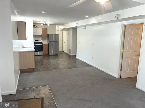 a view of kitchen with refrigerator and cabinets