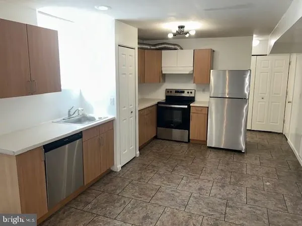 a kitchen with stainless steel appliances granite countertop a refrigerator a sink and a stove