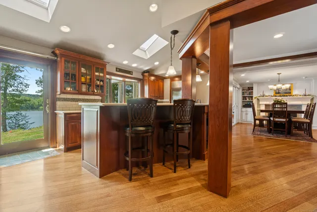 a dining hall with stainless steel appliances kitchen island granite countertop a refrigerator and cabinets