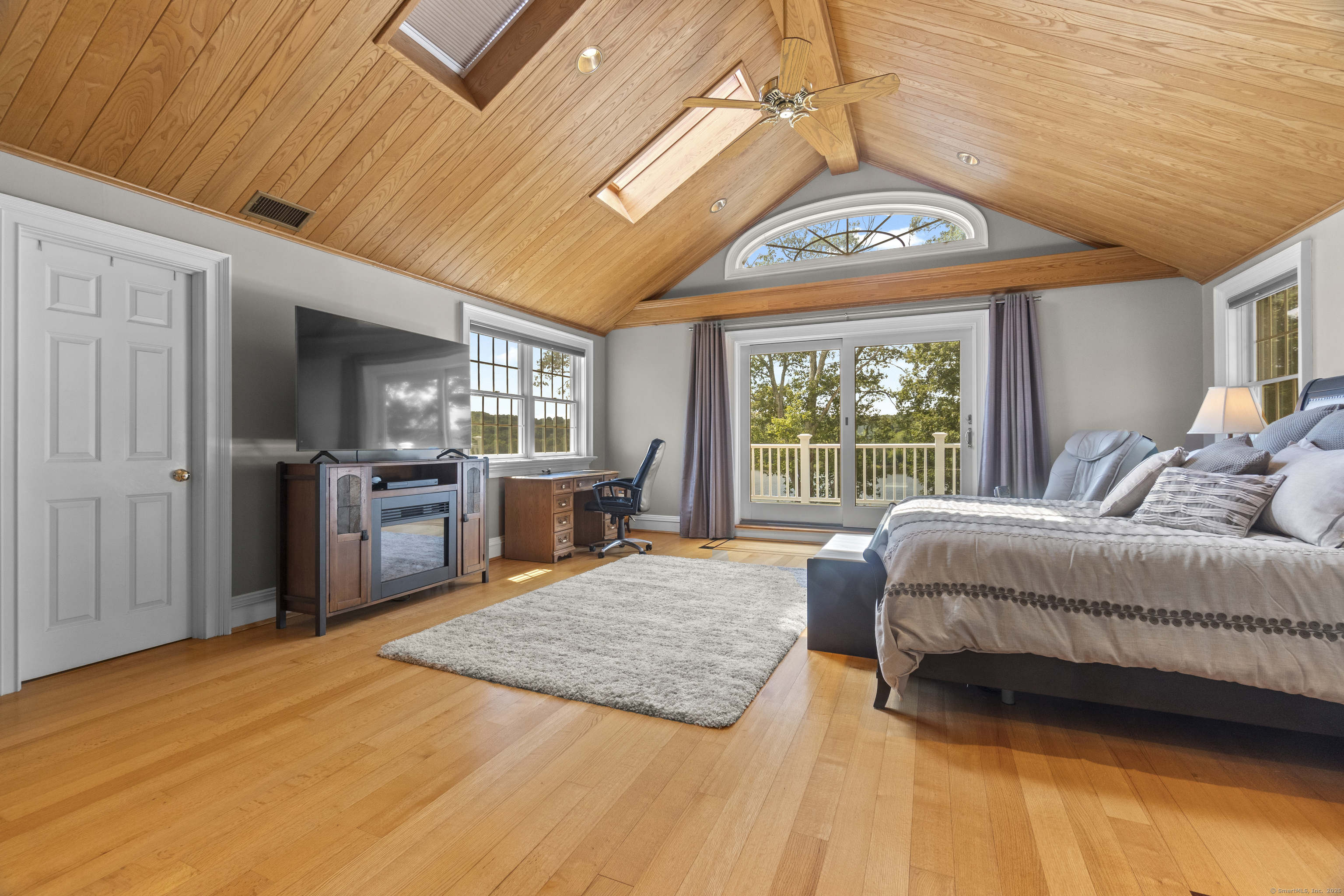 291 Injun Hollow Road Haddam, CT 06424 - Photo 17 of 30 a spacious bedroom with a large bed a chandelier and windows