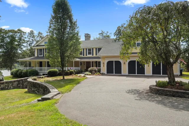 an aerial view of residential houses with outdoor space and lake view