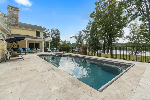 a view of swimming pool with outdoor seating and lake view