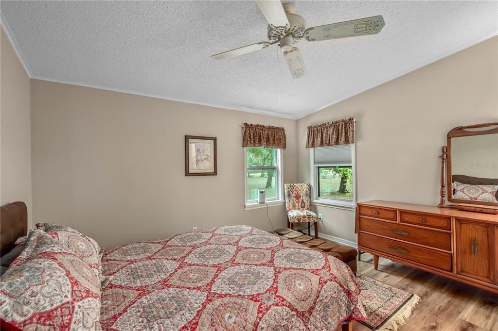 112 Magnolia Street Hawthorne, FL 32640 - Photo 19 of 41 a bedroom with a bed and a dresser with the potted plants