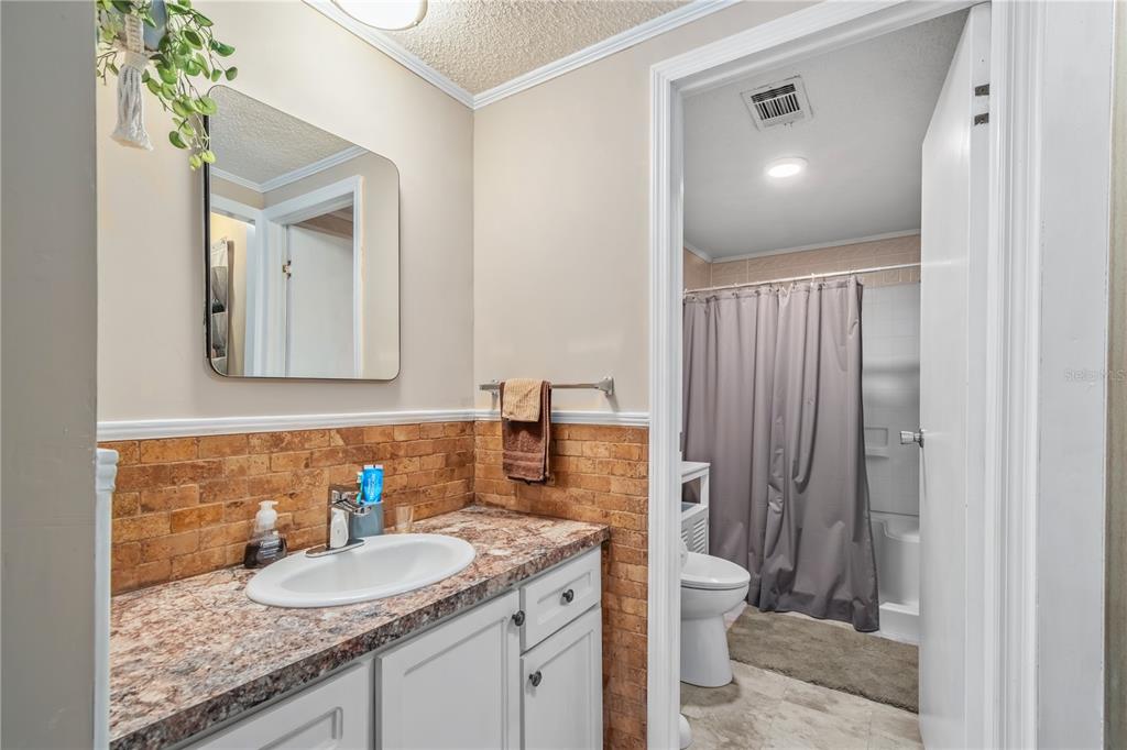 112 Magnolia Street Hawthorne, FL 32640 - Photo 21 of 41 a bathroom with a granite countertop sink a toilet and a mirror