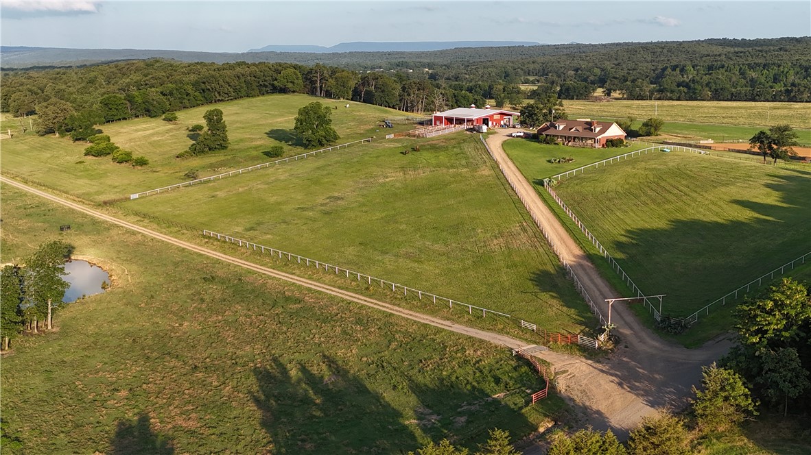 2210 Weiterer Road Scranton, AR 72863 - Photo 38 of 49 Expansive acreage featuring a main residence, a red barn structure, a private pond, and extensive fencing