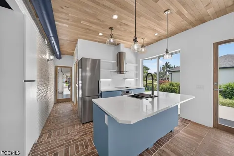 a kitchen with stainless steel appliances granite countertop a sink and a refrigerator