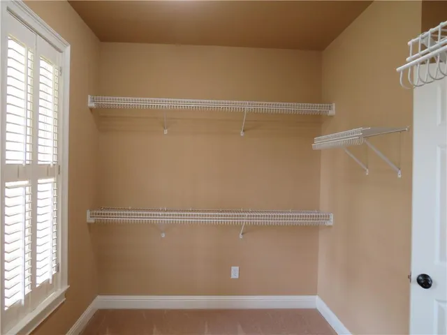 a view of a closet with wooden floor