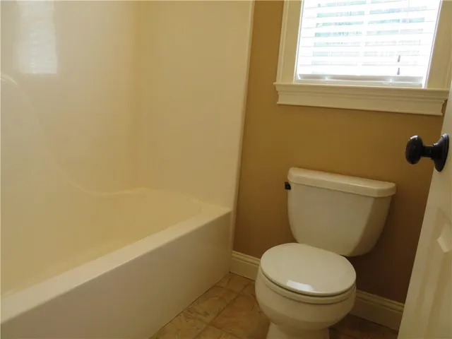 a white toilet sitting next to a window