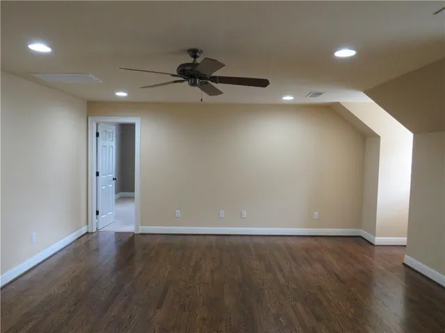 a view of a big room with wooden floor and a ceiling fan