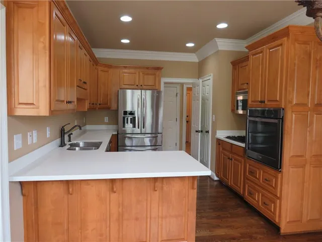 a kitchen with stainless steel appliances a refrigerator and wooden cabinets
