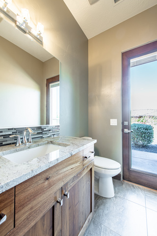 322 340 E Street Ivins, UT 84738 - Photo 22 of 61 Bathroom vanity featuring a rectangular undermount sink, stone countertop, and tile backsplash
