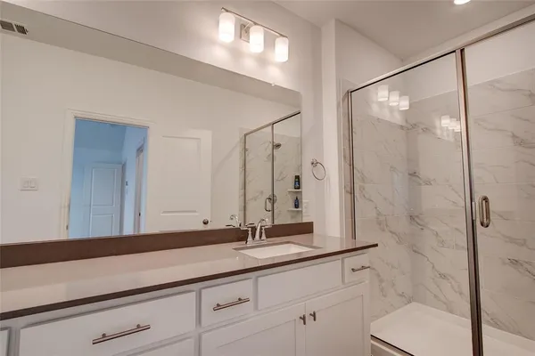 a bathroom with a shower sink and mirror