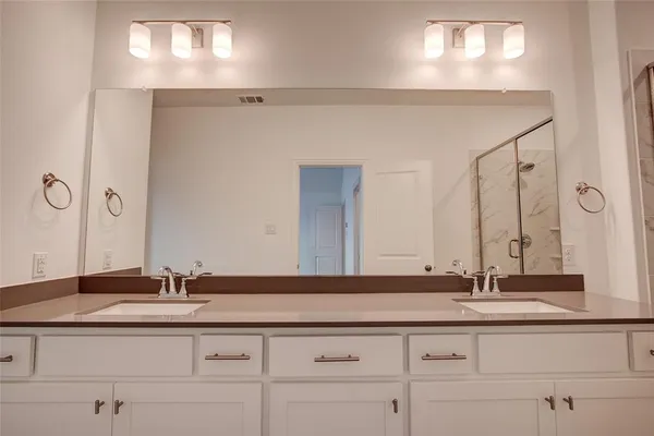 a bathroom with double sink and a mirror