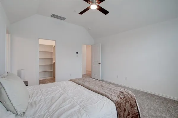 a bedroom with a bed and a ceiling fan