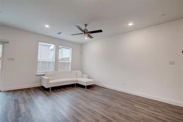 a living room with furniture and kitchen area