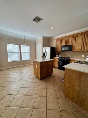 a kitchen with stainless steel appliances a stove a sink a microwave and cabinets