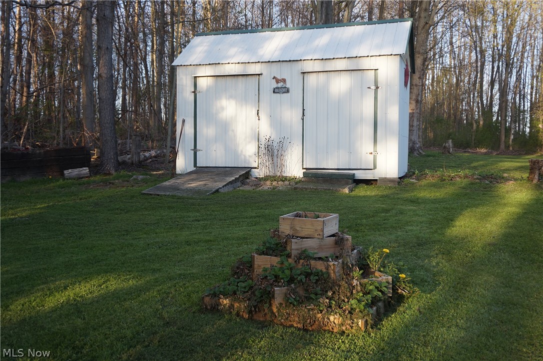 2605 Plymouth Ridge Road Ashtabula, OH 44004 - Photo 43 of 50 View of shed / structure with a yard are with strawberry planters in front.