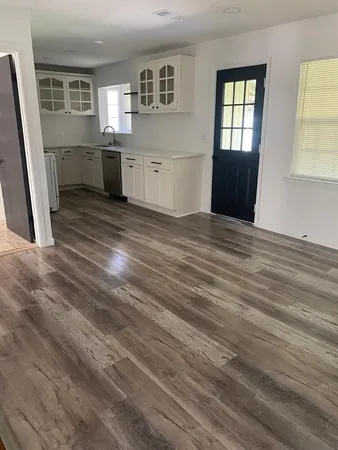 a view of empty room with window and wooden floor