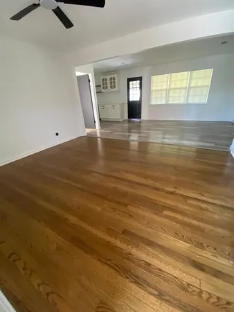a view of empty room with window and wooden floor