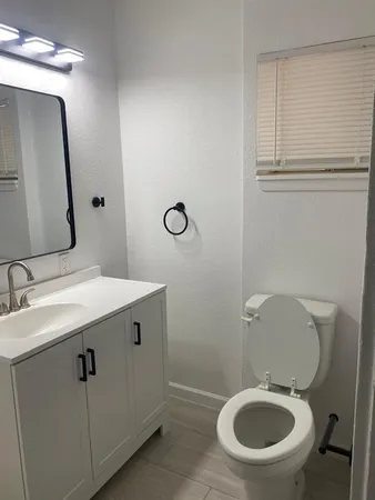 a bathroom with a toilet sink and mirror