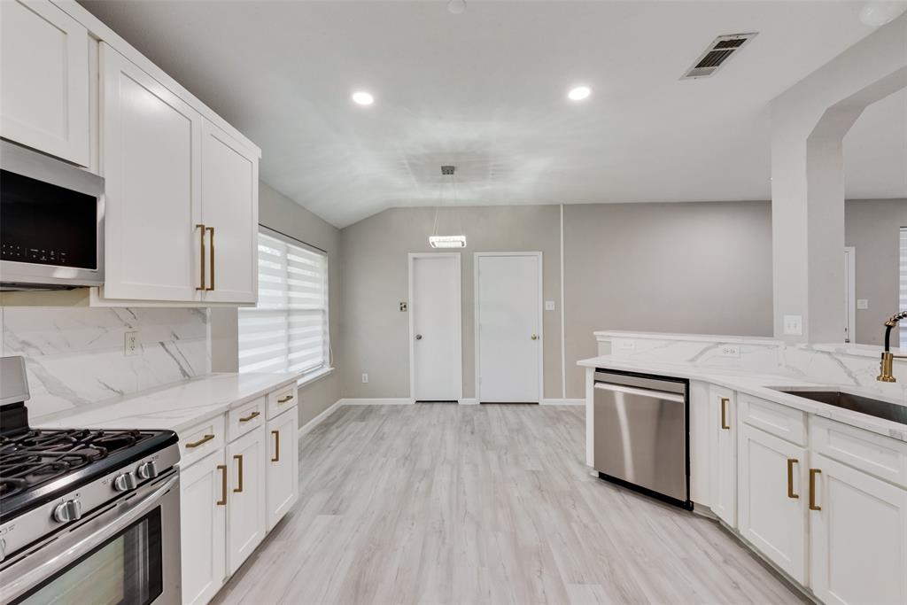 506 Pecos Path Drive Murphy, TX 75094 - Photo 9 of 19 a kitchen with granite countertop a sink cabinets and stainless steel appliances